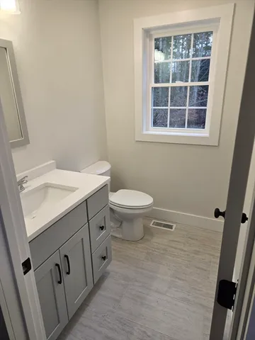 a bathroom with a sink a toilet and a window