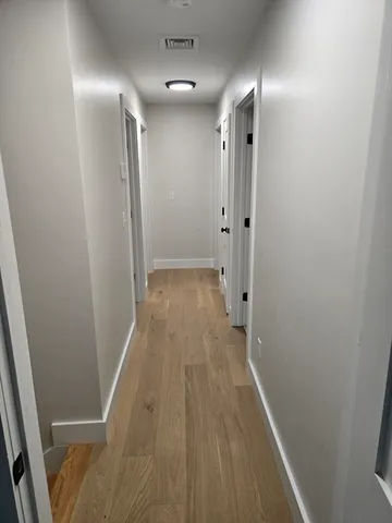 a view of hallway with wooden floor