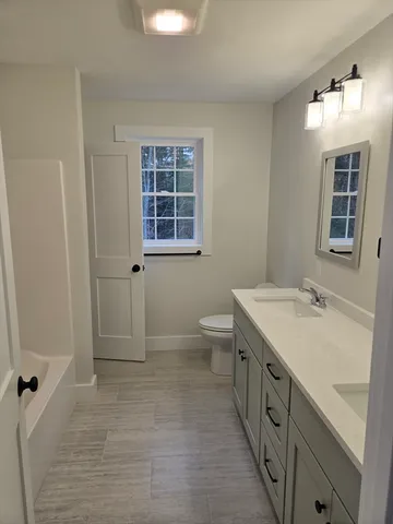 a bathroom with a granite countertop sink toilet and shower