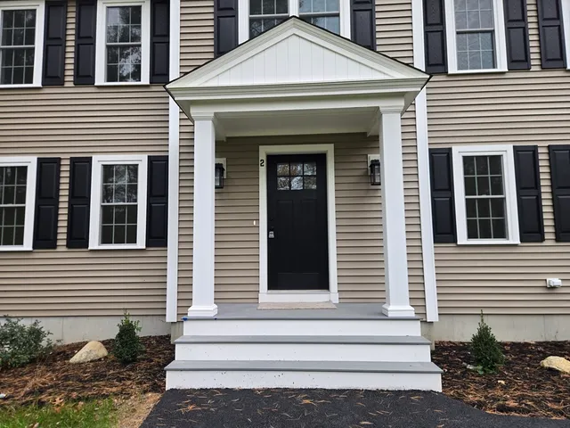 a front view of a house with plants and entryway windows
