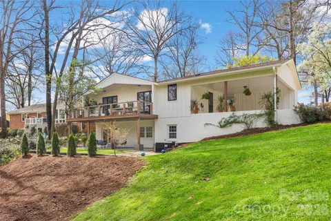 a view of a house with backyard and a tree