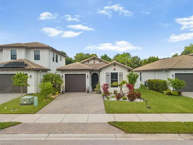 a front view of a house with a yard and potted plants