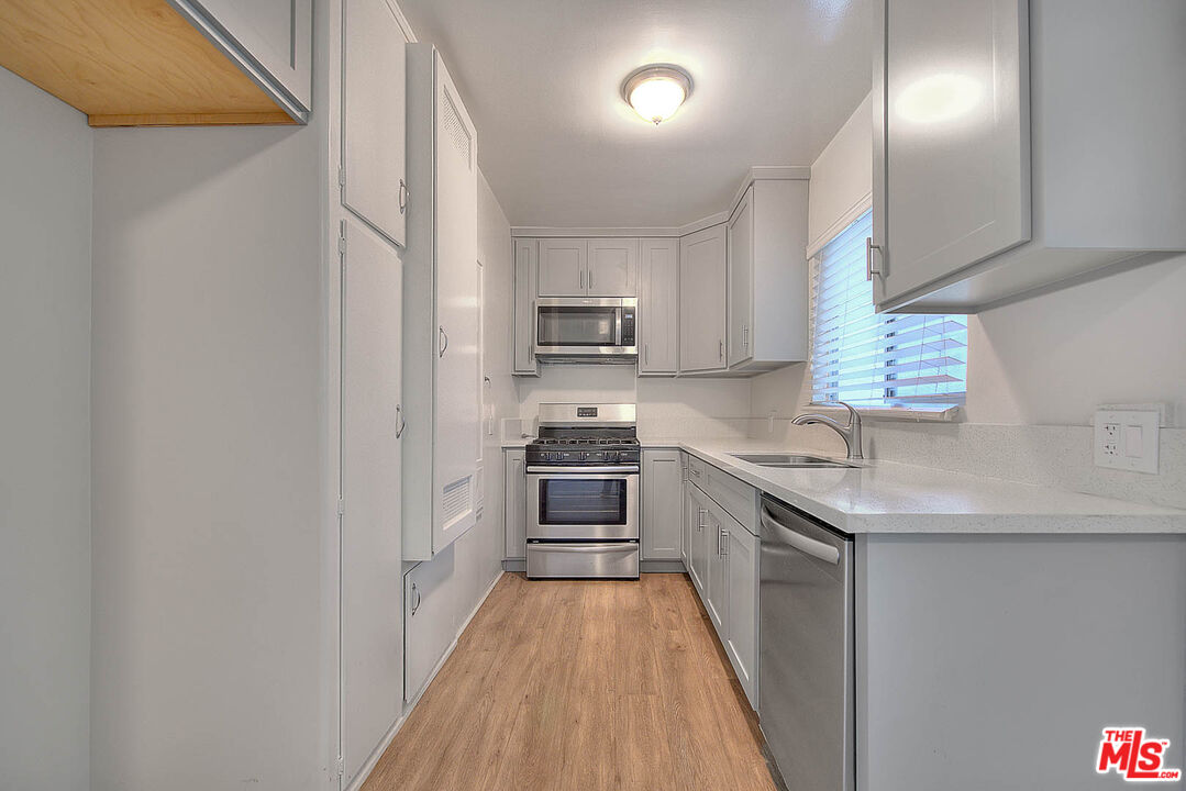 7017 Ramsgate Place Los Angeles, CA 90045 - Photo 13 of 32 a kitchen with granite countertop a sink a stove top oven and refrigerator