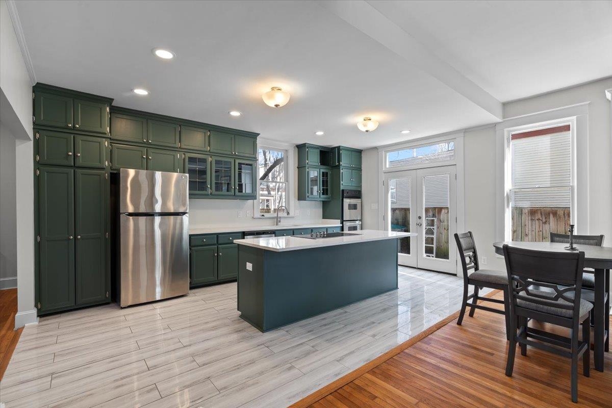 1682 Lawrence Avenue Memphis, TN 38112 - Photo 13 of 33 a kitchen with stainless steel appliances granite countertop a refrigerator a sink dishwasher a stove and a dining table with wooden floor