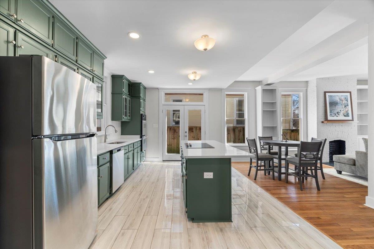 1682 Lawrence Avenue Memphis, TN 38112 - Photo 2 of 33 a kitchen with stainless steel appliances granite countertop a refrigerator a stove top oven a dining table and chairs with wooden floor