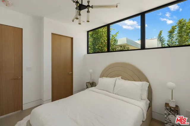 a bedroom with a bed and glass wall painting