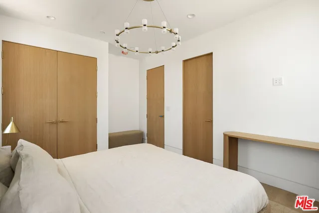 a bedroom with a bed and a chandelier