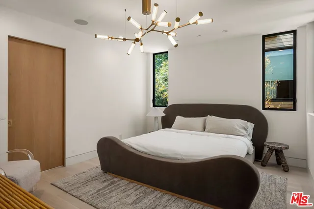 a bedroom with a bed mirror and window