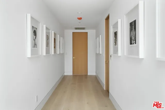 a view of a hallway with wooden shelves