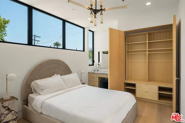 a bedroom with a bed and a flat tv screen on dresser