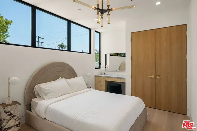 a bedroom with a large bed and a chandelier