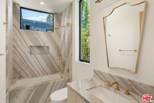 a bathroom with a granite countertop sink toilet and shower