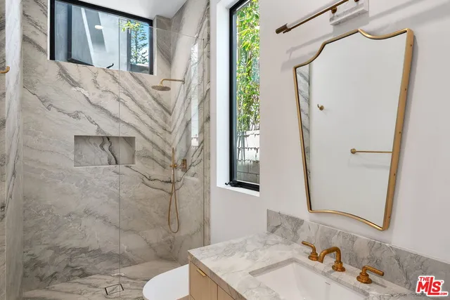 a bathroom with a sink a toilet and shower