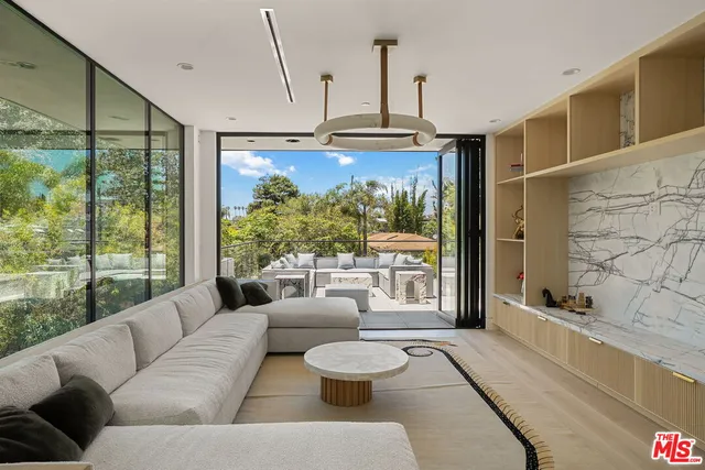 a living room with patio furniture and a floor to ceiling window