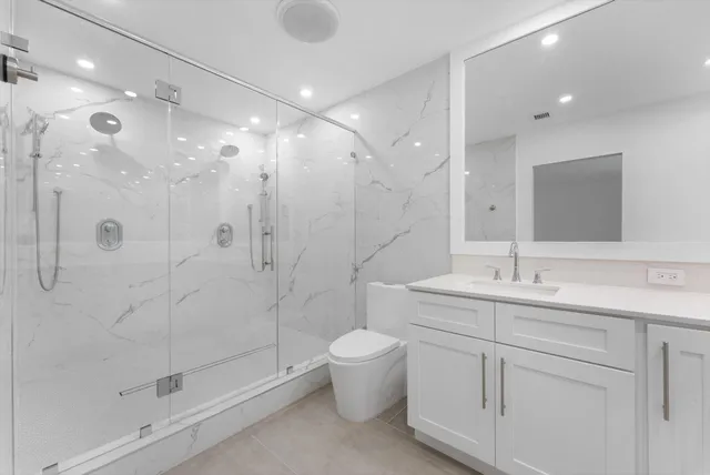 a bathroom with a double vanity sink mirror and toilet