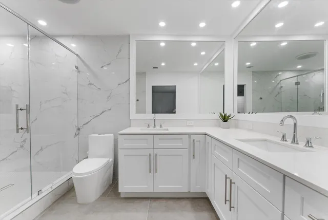 a bathroom with a double vanity sink mirror and toilet