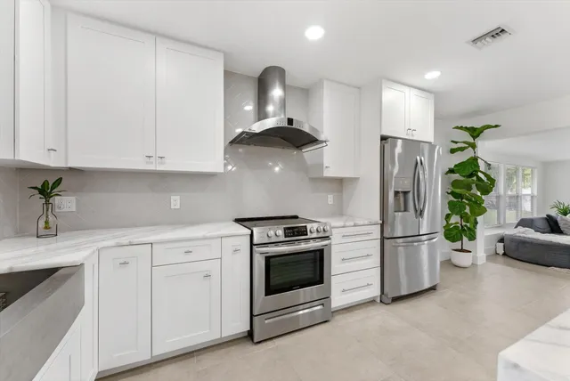 a kitchen with stainless steel appliances a stove refrigerator sink and cabinets