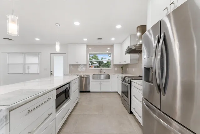 a kitchen with white cabinets and stainless steel appliances