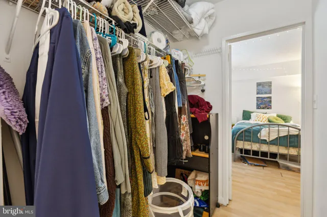 a view of walk in closet with clothes and shoes