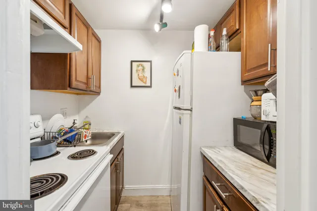 a kitchen with stainless steel appliances granite countertop a refrigerator and a stove