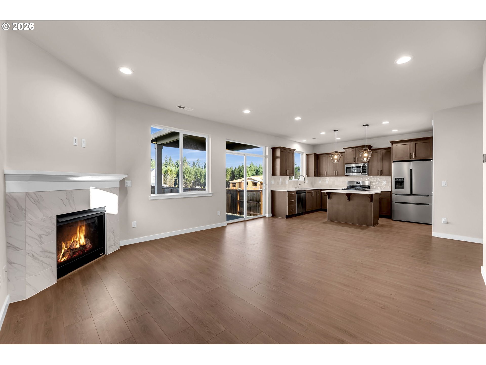 4308 Northeast 185th Street Vancouver, WA 98686 - Photo 6 of 41 a view of a living room a kitchen with furniture wooden floor and a fireplace