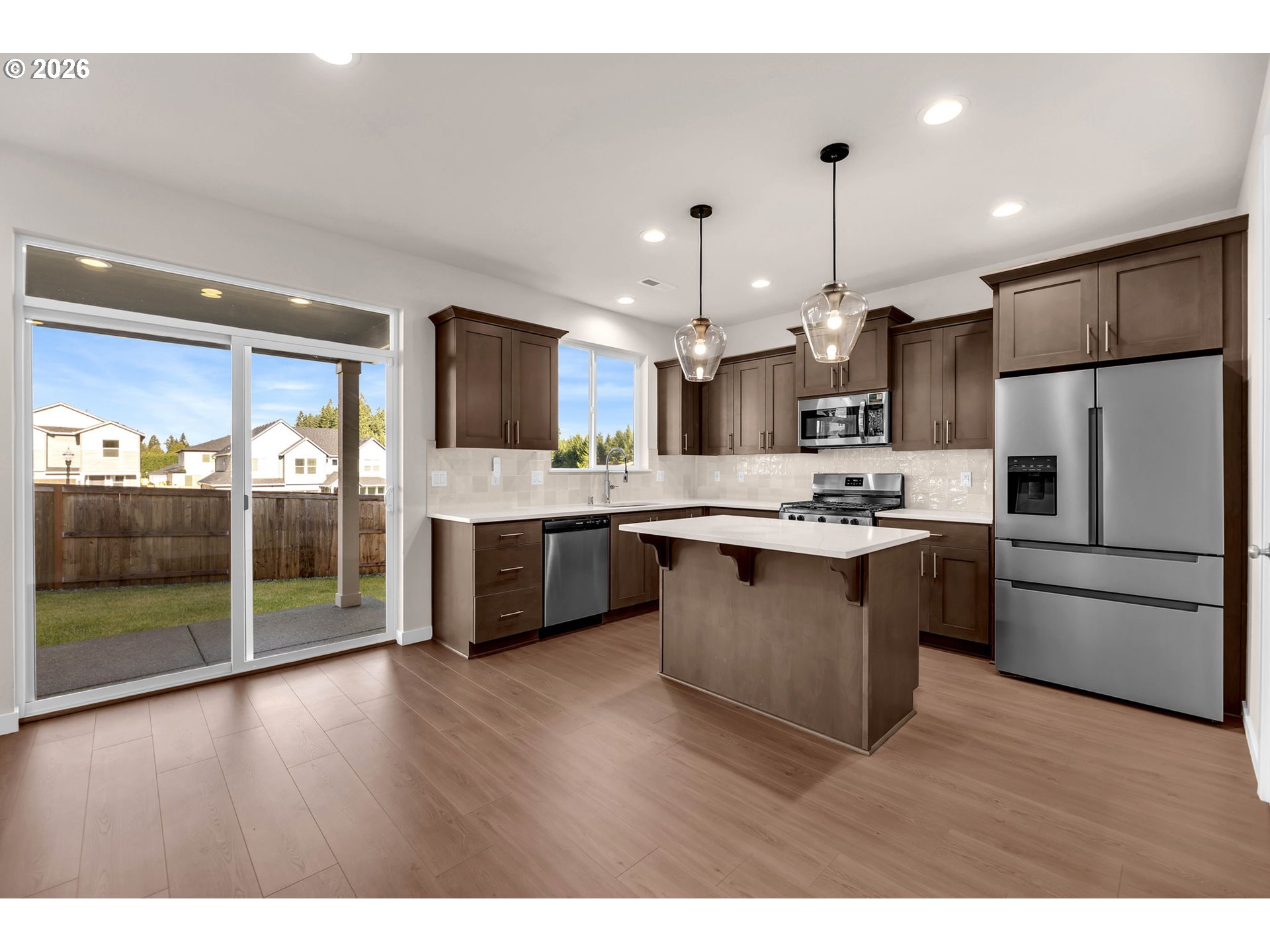 4308 Northeast 185th Street Vancouver, WA 98686 - Photo 10 of 41 a kitchen with stainless steel appliances kitchen island granite countertop a refrigerator a sink dishwasher a oven and a large countertops with wooden floor