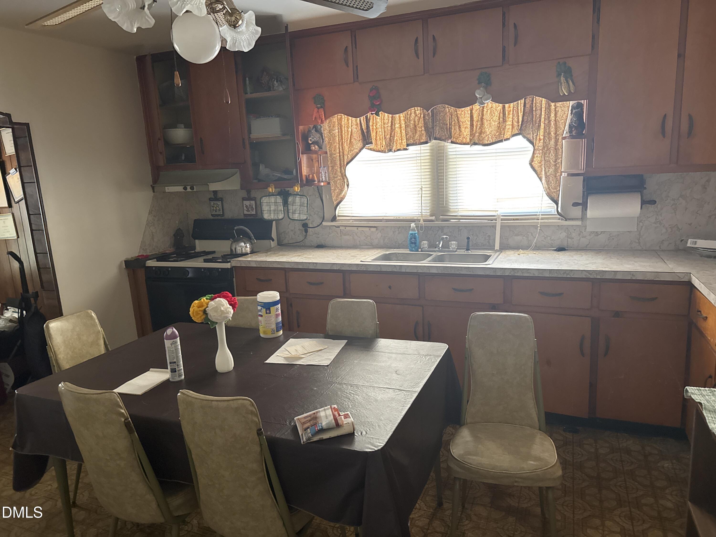 213 Hill Street Roxboro, NC 27573 - Photo 5 of 13 a kitchen with a dining table chairs and a stove top oven