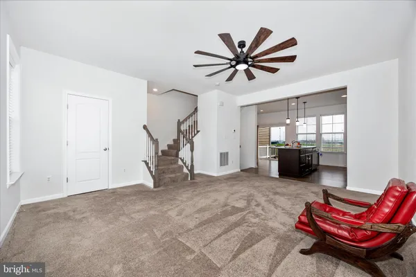 a kitchen with stainless steel appliances granite countertop a dining table chairs and a refrigerator