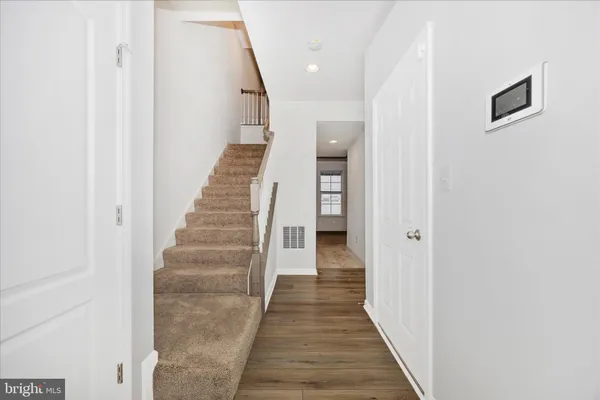 a view of a hallway with wooden floor and entryway