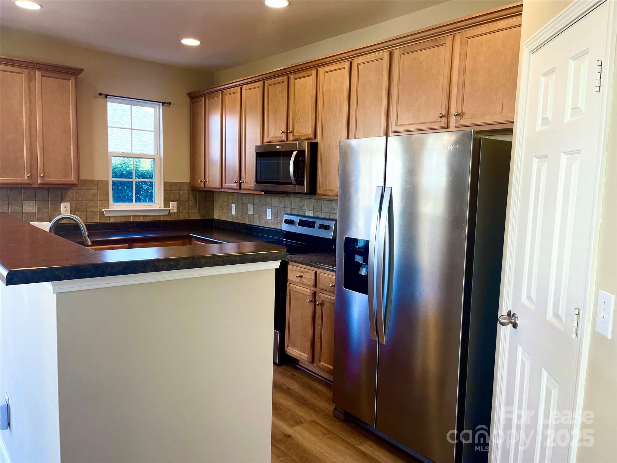 233 East Waterlynn Road, Unit A Mooresville, NC 28117 - Photo 3 of 13 a kitchen with stainless steel appliances granite countertop a refrigerator and a sink