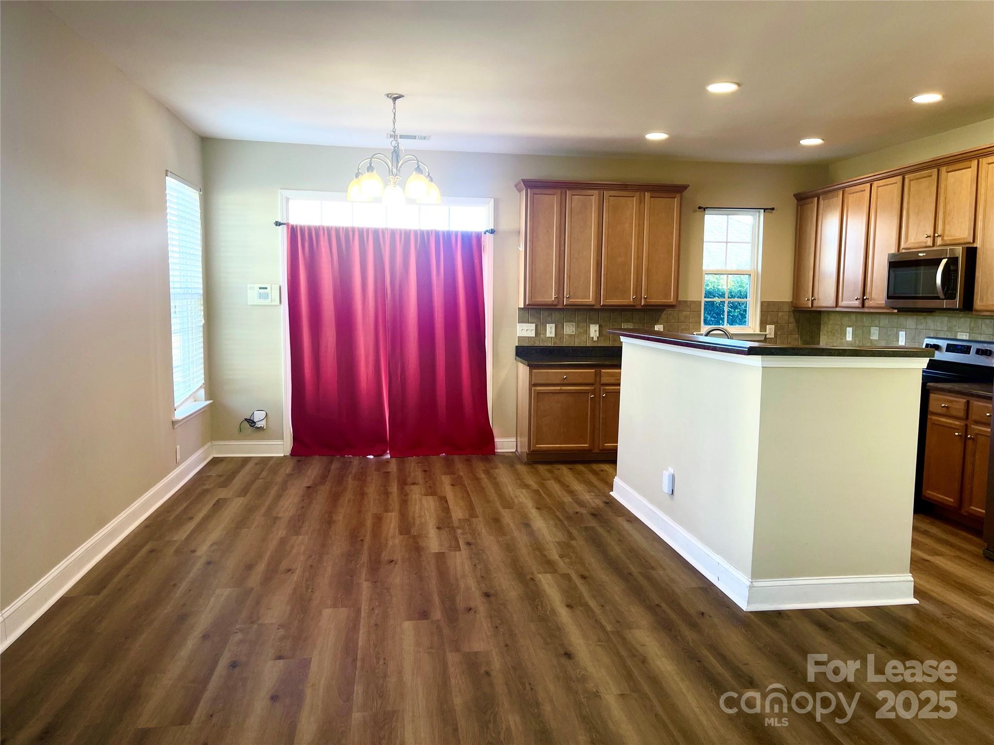 233 East Waterlynn Road, Unit A Mooresville, NC 28117 - Photo 5 of 13 a kitchen with stainless steel appliances granite countertop a refrigerator sink and wooden cabinets