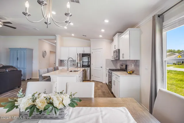 a living room with furniture and kitchen view