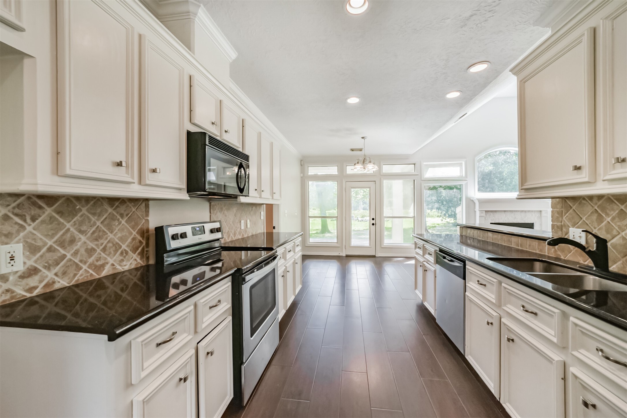 27322 Afton Way Huffman, TX 77336 - Photo 18 of 50 Chef-inspired kitchen boasts abundant counter space, custom cabinetry, and picturesque views into the living and dining areas.