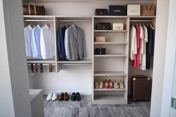 a view of walk in closet with clothes and shoes