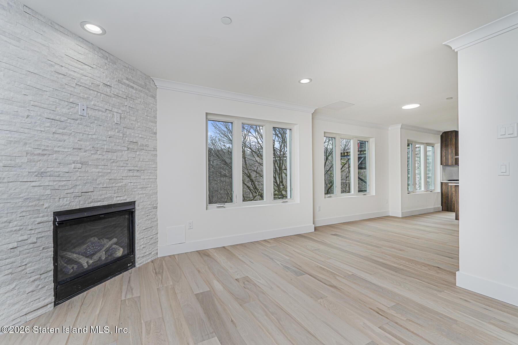 54 Cedarcliff Road Staten Island, NY 10301 - Photo 8 of 49 a view of an empty room with wooden floor fireplace and a window