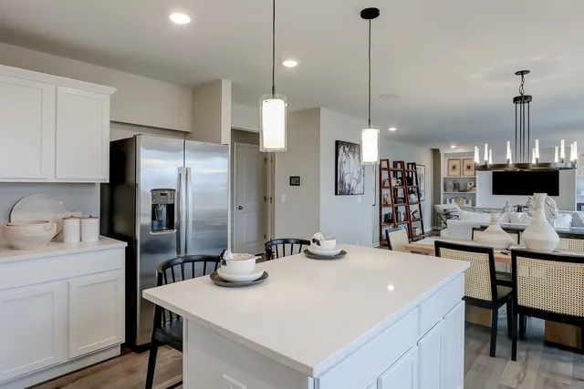 a kitchen with stainless steel appliances kitchen island granite countertop a sink a refrigerator and a stove