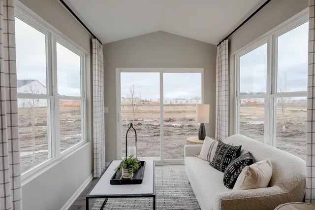 a living room with furniture and floor to ceiling windows