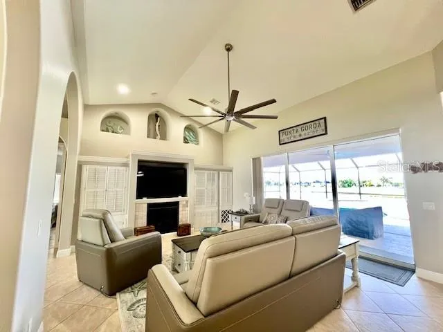 a living room with furniture a fireplace and a flat screen tv