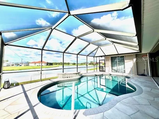 a living room with patio furniture and a floor to ceiling window