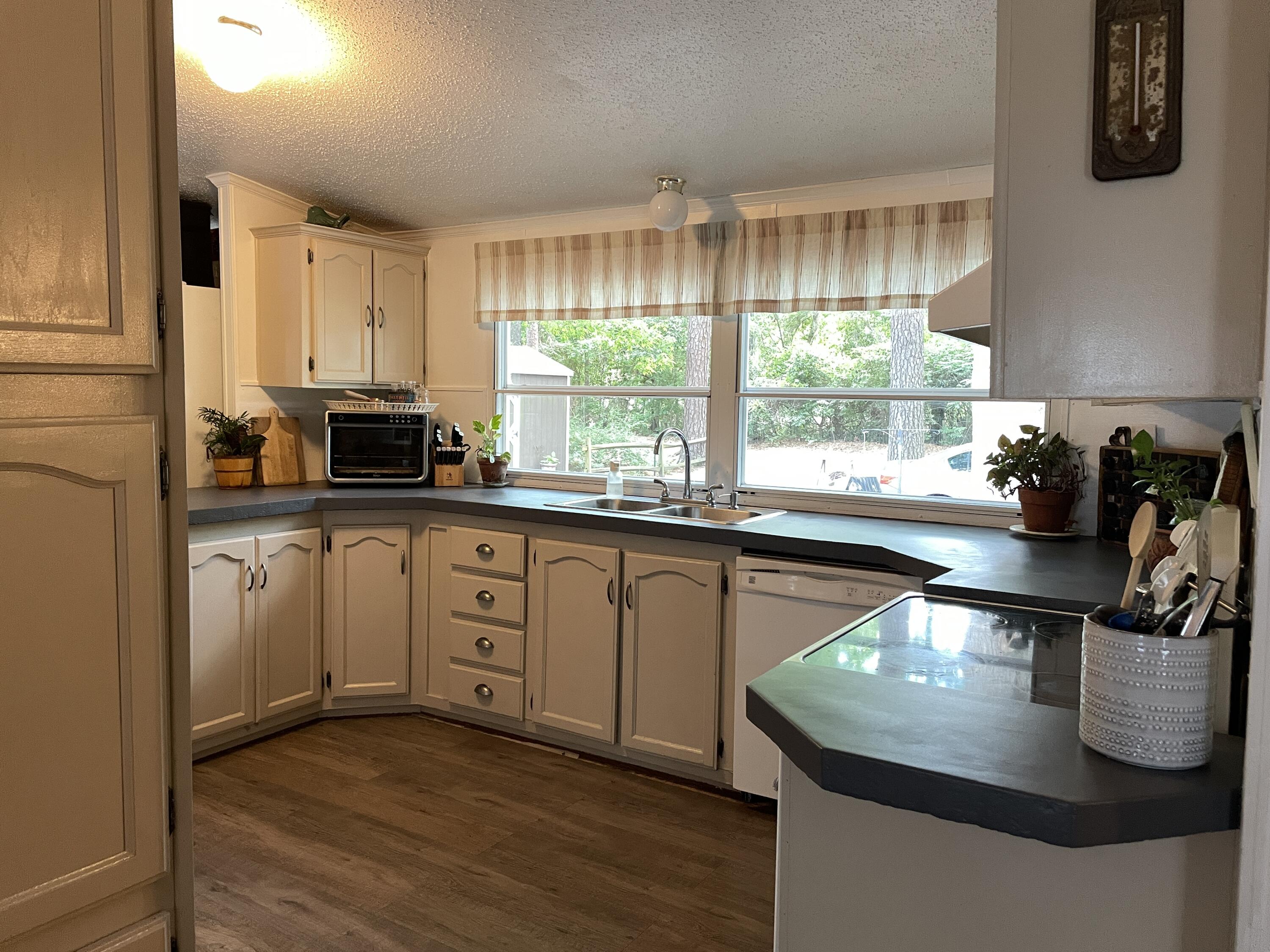 2166 Healing Springs Road Blackville, SC 29817 - Photo 8 of 43 a kitchen with stainless steel appliances granite countertop a sink a stove and a wooden floor
