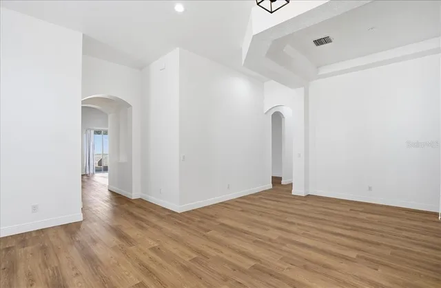 a view of empty room with wooden floor