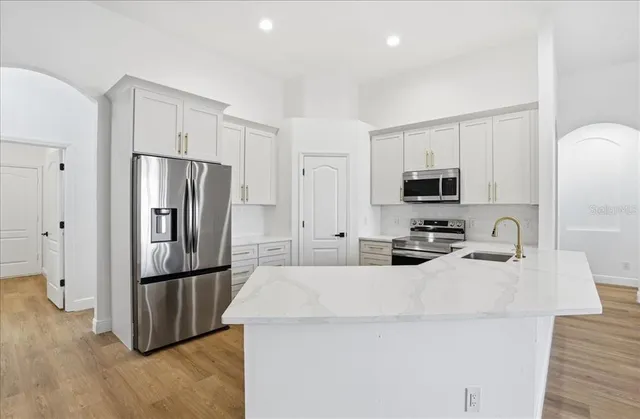 a kitchen with stainless steel appliances a refrigerator stove microwave and sink