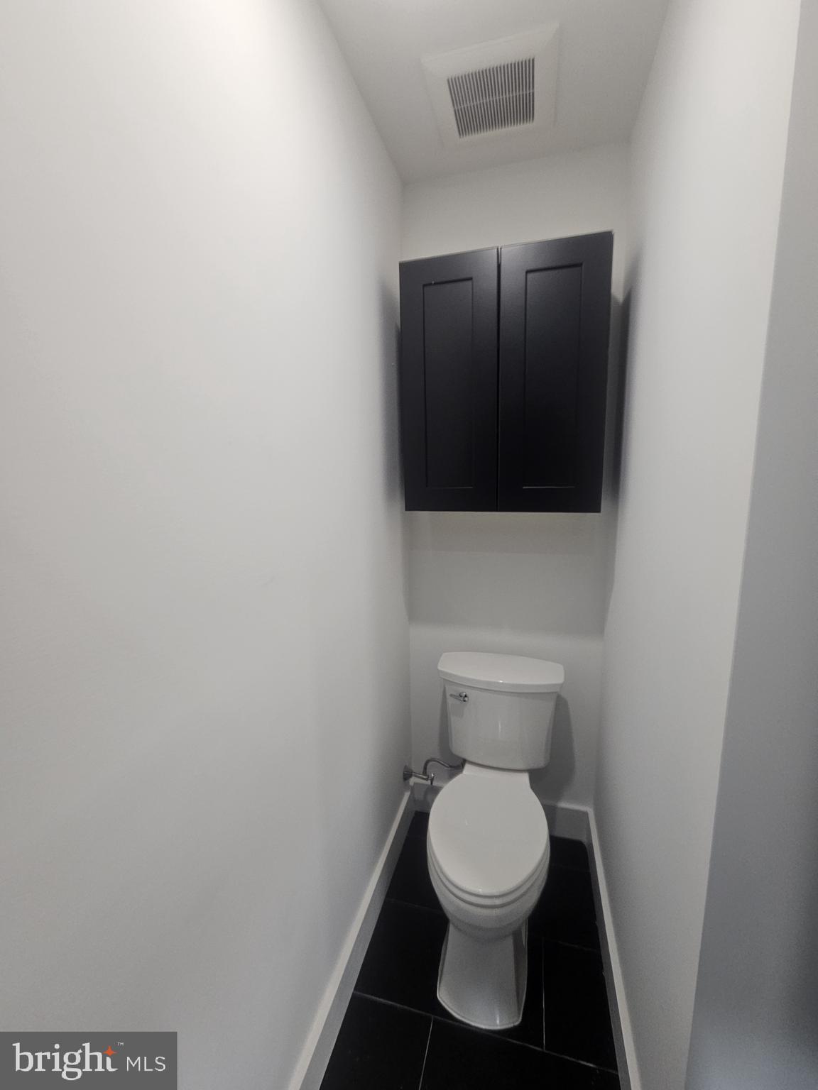 1250 North 18th Street, Unit 1 Philadelphia, PA 19121 - Photo 17 of 26 a white toilet sitting in a bathroom next to a wooden wall