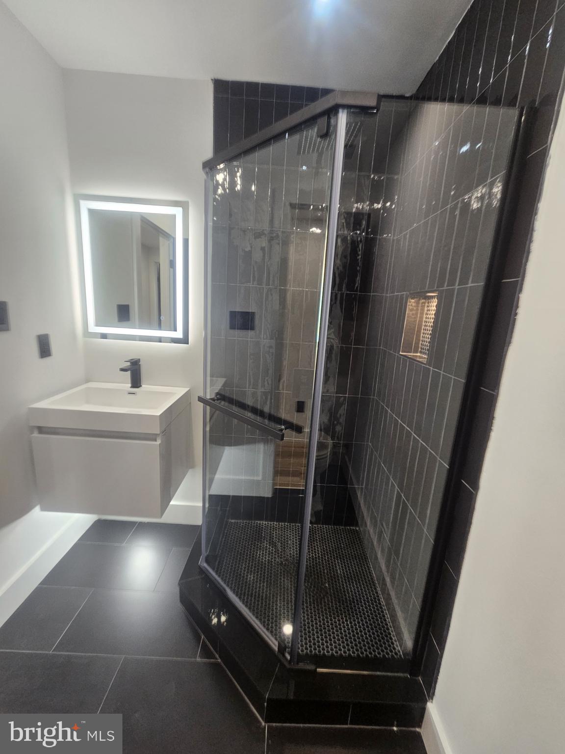 1250 North 18th Street, Unit 1 Philadelphia, PA 19121 - Photo 7 of 26 a bathroom with a sink a toilet a mirror and shower