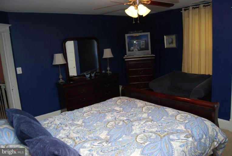 26621 Ridge Road Damascus, MD 20872 - Photo 12 of 18 a bedroom with a bed and a chandelier