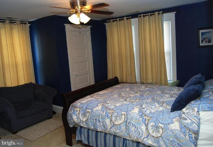 26621 Ridge Road Damascus, MD 20872 - Photo 15 of 18 a bedroom with a bed and a chandelier