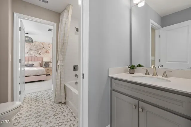 a en suite bathroom with a granite countertop sink and a mirror