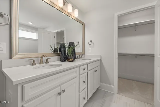 a spacious bathroom with a double vanity sink and mirror