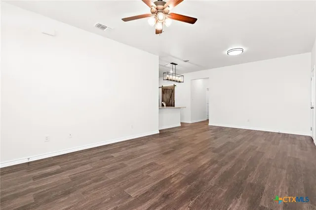a view of a room with wooden floor and ceiling fan