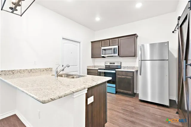 a kitchen with a refrigerator a stove a sink and a refrigerator